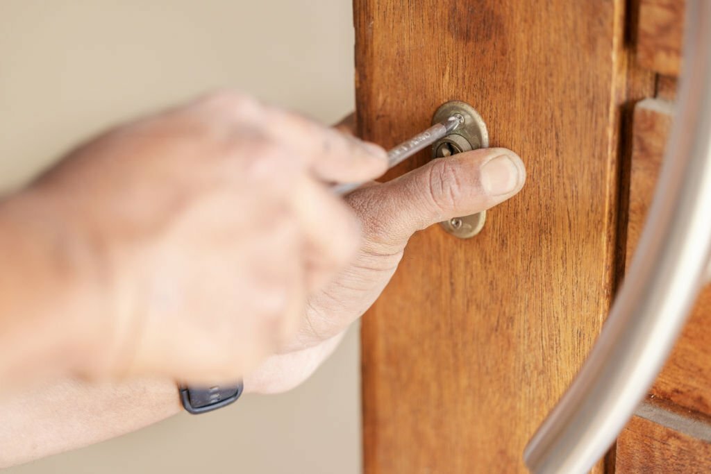 Locksmith hands, maintenance and handyman with home renovation and fixing, change door locks with tool and closeup. Construction, building industry and trade with manual labour, vocation and employee