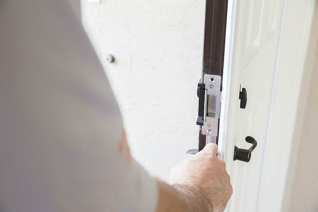 Construction: Contractor installing security lock.  rr